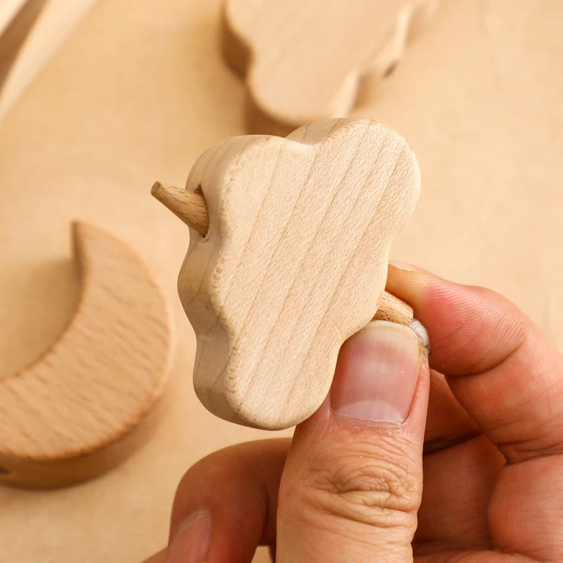 close up of threading a wooden cloud 